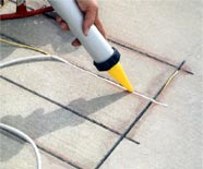 Applying sealant to a radiant heat retrofit installation.
