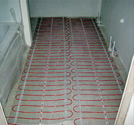 Electric radiant floor heating mats being installed on bathroom floor